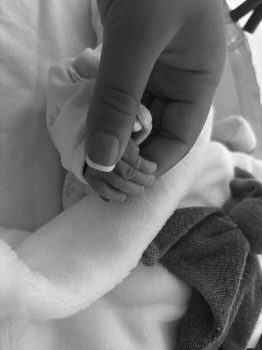 Kairo's tiny hand held by his family